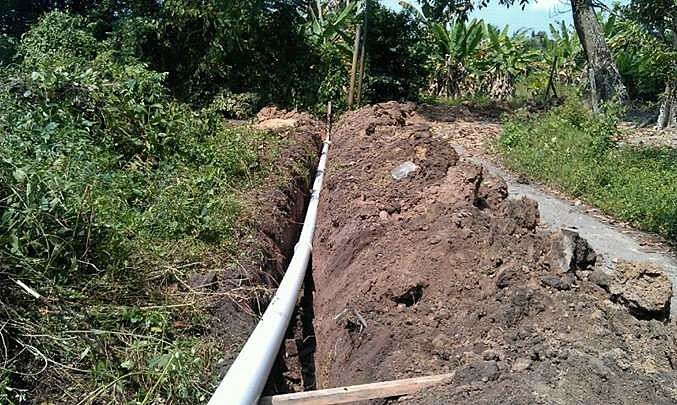Water supply pipe laid in an open trench through vegetation