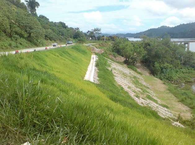 Long grassed embankment with a concrete berm drain running down it